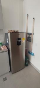 a metallic refrigerator in a kitchen with two mop at Santa marina in Santa Marta