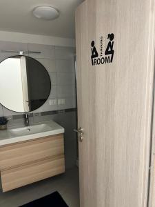 a bathroom with a sink and a mirror and a door at Come A To Casa in Aspra +11 photos