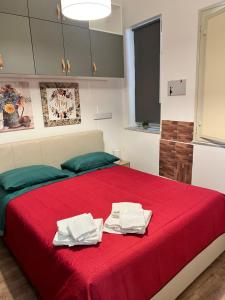 a bedroom with a red bed with towels on it at Come A To Casa in Aspra
