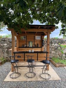 an outdoor bar with stools in front of a building at Residencia Bambou HAVRE DE PAIX in Juan Dolio