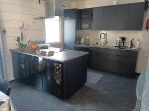 a kitchen with black cabinets and a counter top at Villa Naava in Lukkarinsaari