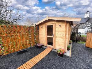 a small wooden shed with a fence and flowers at Private Heated Bedrooms at The Bunkhouse in Snowdonia Perfect for Bikers and Walkers in Dolgellau +11 photos