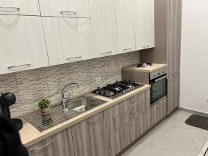 a kitchen with a sink and a stove at Come A To Casa in Aspra
