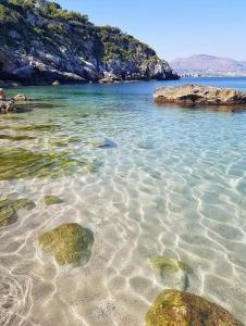 a beach with rocks in the water at Come A To Casa in Aspra