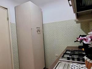 a kitchen with a white refrigerator next to a stove at Mare&Monti II Guest House with Private Parking in Telti