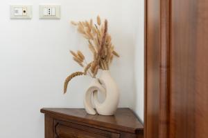 a white vase with a plant in it on a table at Villa Fenix Seriate in Seriate
