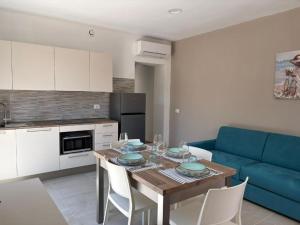 a living room with a table and a blue couch at Acquaviva Suite in San Vincenzo