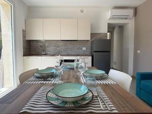 a table with plates and glasses on it in a kitchen at Acquaviva Suite in San Vincenzo