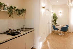 a kitchen with a sink and a table with chairs at SOFIA Suites & Rooms in Pompei