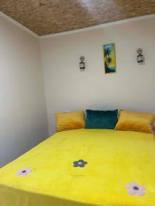 a bedroom with a yellow bed with flowers on it at Guest House Chalastavi in Godogani
