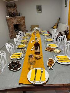 a long table with yellow napkins and plates on it at Guest House Chalastavi in Godogani