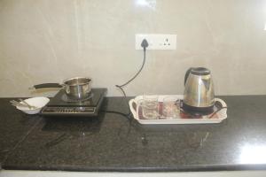 a kitchen counter with a coffee maker and a tea kettle at Yogi Ram Guest House in Tiruvannāmalai +14 photos