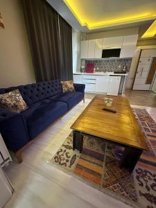 a living room with a blue couch and a coffee table at Zirve Suit Rezidans in Talas
