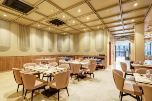 a restaurant with tables and chairs in a room at Airport Premier In With Free Airport Drop in New Delhi