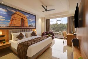 a hotel room with a bed and a desk and a window at Airport Premier In With Free Airport Drop in New Delhi