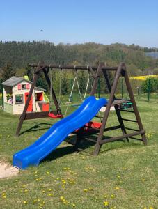 a playground with a blue slide and a swing at Panorama Hotel am Frankenstein in Bad Salzungen