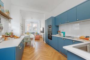 a kitchen with blue cabinets and a dining room at Beachway House in Weymouth