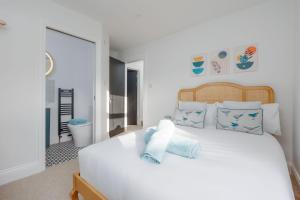 a bedroom with a white bed with blue pillows at Beachway House in Weymouth
