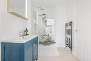 a bathroom with a blue sink and a shower at Beachway House in Weymouth +27 photos