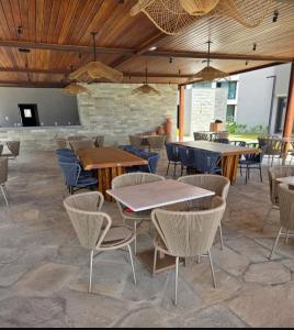a restaurant with tables and chairs in a room at Beira mar Flat Deluxe Nomar Carneiros Ecoliving Réveillon in Tamandaré