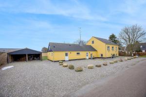 a yellow building with a garage and a barn at Fewo Vidstrup Hygge in Vidstrup