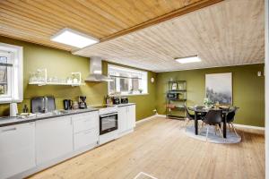 a kitchen with white cabinets and a table with chairs at Fewo Vidstrup Hygge in Vidstrup