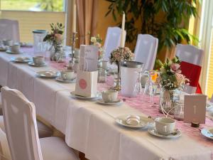 a long table with white table cloth and white chairs at Panorama Hotel am Frankenstein in Bad Salzungen