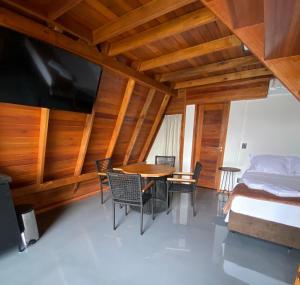 a bedroom with a bed and a table and chairs at LIMMAT Chalés- Presidente Juscelino, MA in Morros