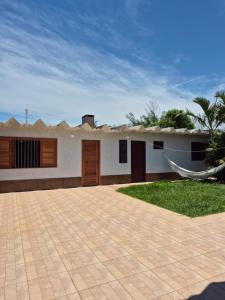 a house with a hammock in front of it at El Tata in Arroio do Silva