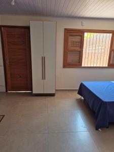 a room with a bed and a cabinet and windows at El Tata in Arroio do Silva