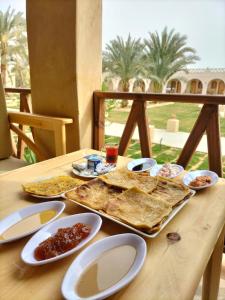 a wooden table with a tray of food on it at SiwaTu Lodge in Siwa