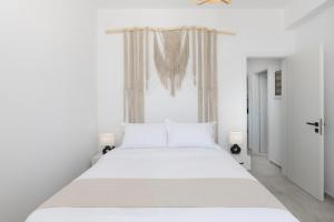 a white bedroom with a large bed with white sheets at Occhio-Nero Cycladic Private Villa with Pool & Sunset View Jacuzzi in Akrotiri +23 photos