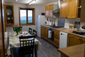 a kitchen with a table with chairs and a white refrigerator at Taftnica in Burray Village