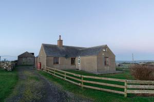 an old house with a fence in front of it at Taftnica in Burray Village