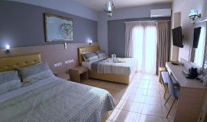 a hotel room with two beds and a window at Thalia deco City & Beach Hotel in Hersonissos