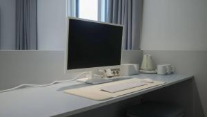 a desk with a computer monitor and a keyboard and mouse at The M Hotel in Seoul