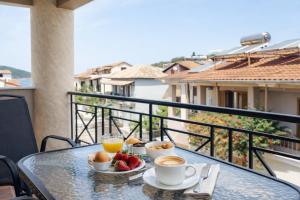 a table with two cups of coffee and fruit on a balcony at villa Fotini 2 (new) in Syvota +40 photos