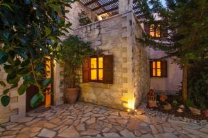 a stone house with windows and a courtyard at Sarris Villa in Áyios Mámas