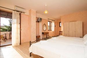 a bedroom with two white beds and a balcony at Sarris Villa in Áyios Mámas +23 photos