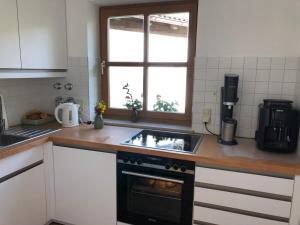 a kitchen with a stove and a window in it at Bergblick Kampenwand in Aschau im Chiemgau