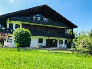 a large yellow house with a wooden roof at Bergblick Kampenwand in Aschau im Chiemgau