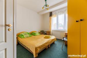 a bedroom with a bed with green pillows at Bursztynek in Gdynia