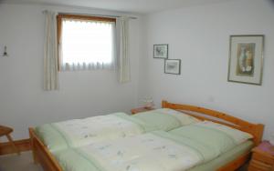 a bed in a room with a window at Champagna in Celerina