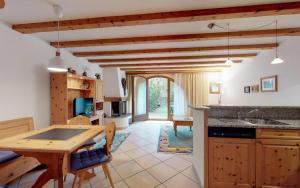 a kitchen with a table and a dining room at Champagna in Celerina +3 photos