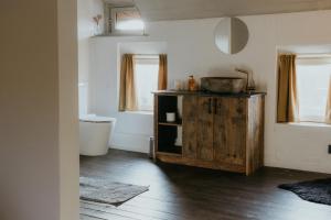 ein Badezimmer mit Waschbecken und einem Holzschrank in der Unterkunft La seiche in Kluisbergen