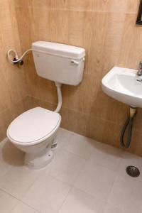 a bathroom with a toilet and a sink at Zest Homes Nugambakkam in Chennai