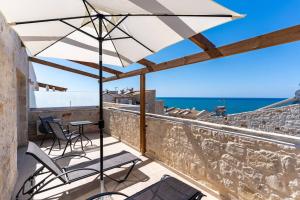 a patio with a table and an umbrella at Symphony Suite in Panormos Rethymno