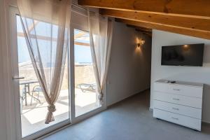 a bedroom with a large window and a television at Symphony Suite in Panormos Rethymno