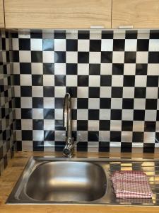 a sink in a kitchen with a checkered wall at Studio Biarritz Côte des Basques in Biarritz