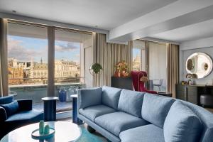a living room with a blue couch and a large window at Sea Containers London in London